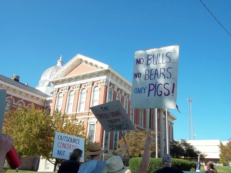 people holding protest signs near a building