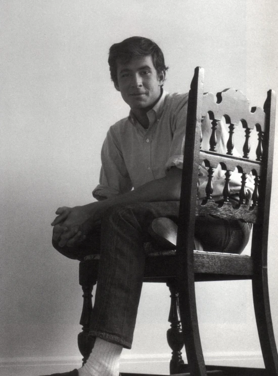 a black and white po of a man sitting on a chair