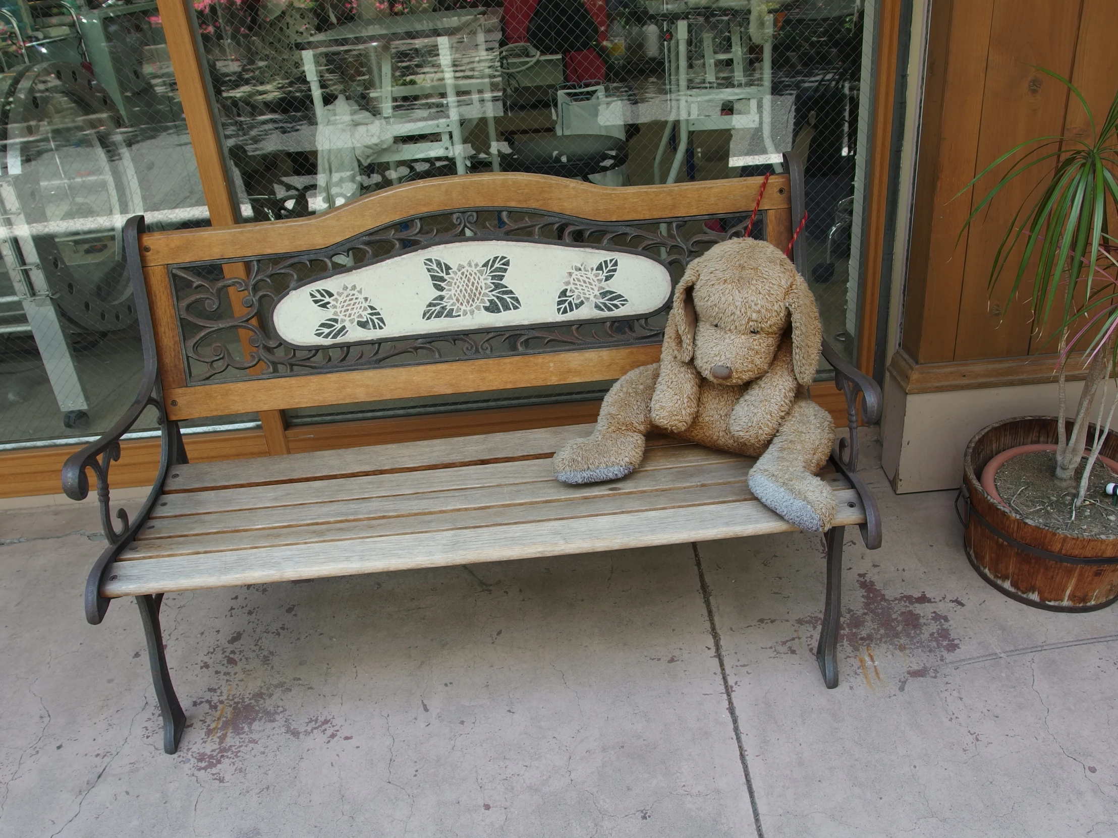 there is a small stuffed teddy bear on the bench