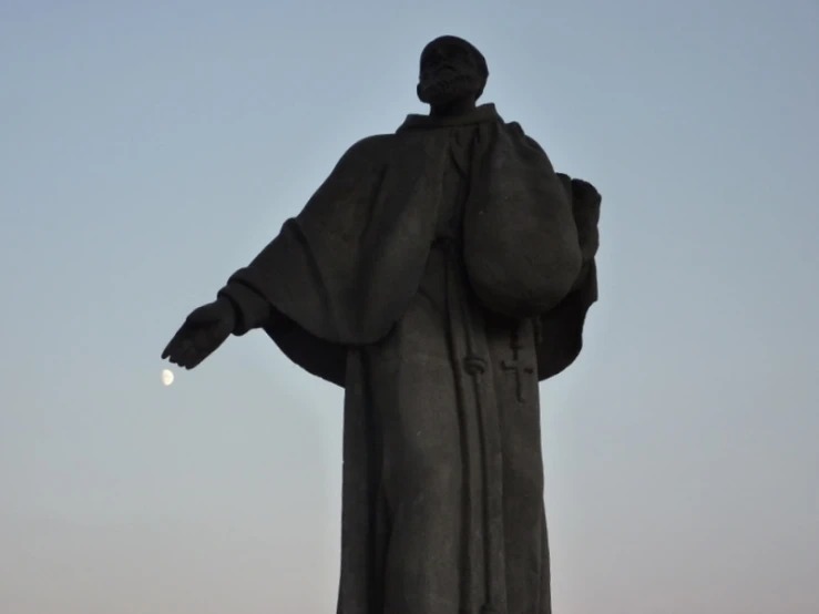 the back of a statue looking up at a light