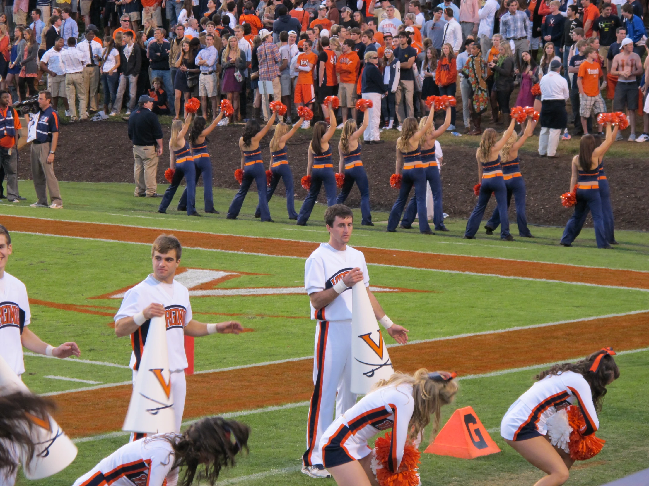 a group of people on a field with cheerleaders