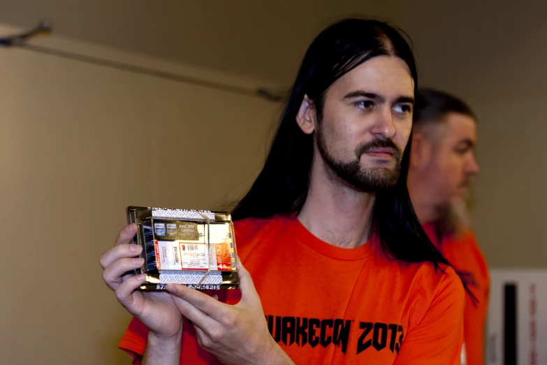 a man with long hair holding a remote