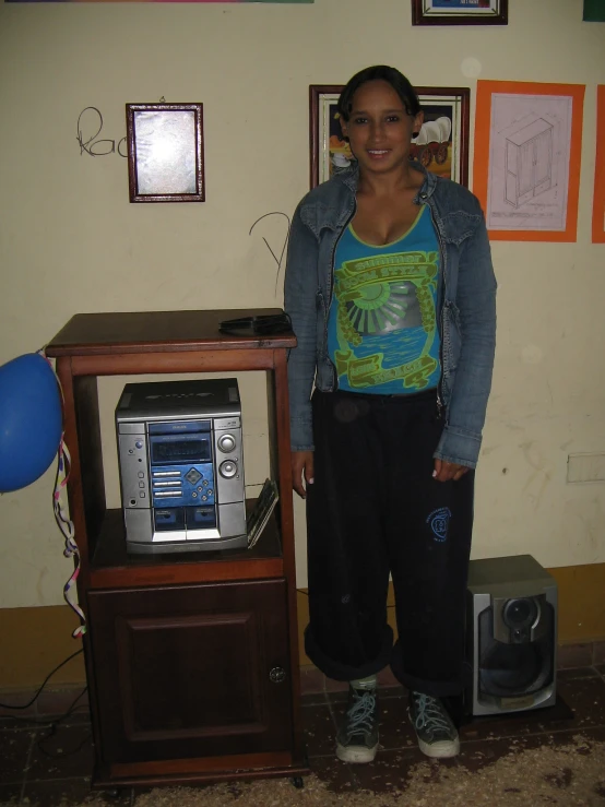a young woman standing next to a stereo and an old style radio