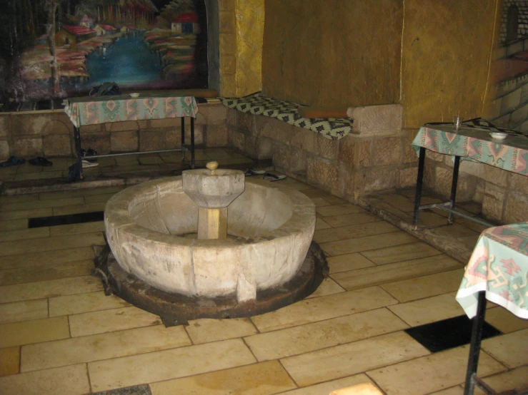 a courtyard with stone tables and benches and paintings in the background