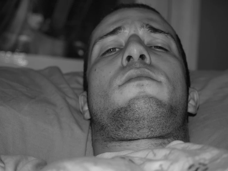 a black and white po of a man laying in bed