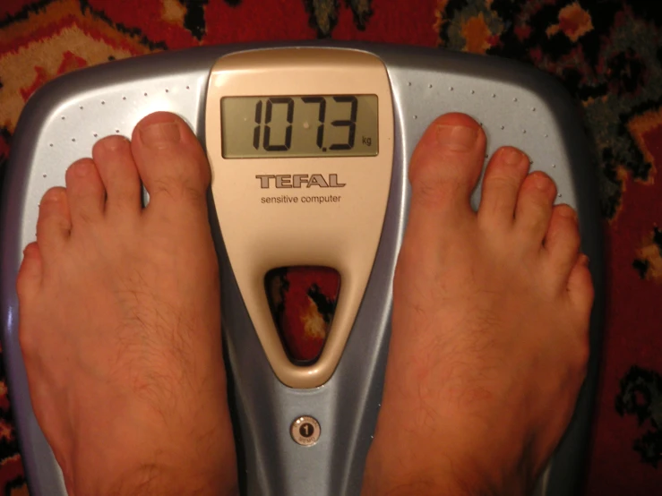 person standing on top of a scale and scale with the numbers on it