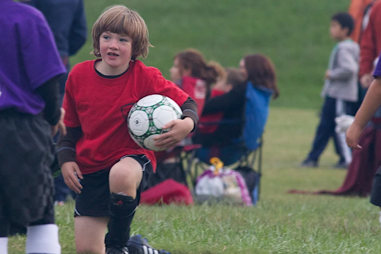  carrying soccer ball at outdoor school event