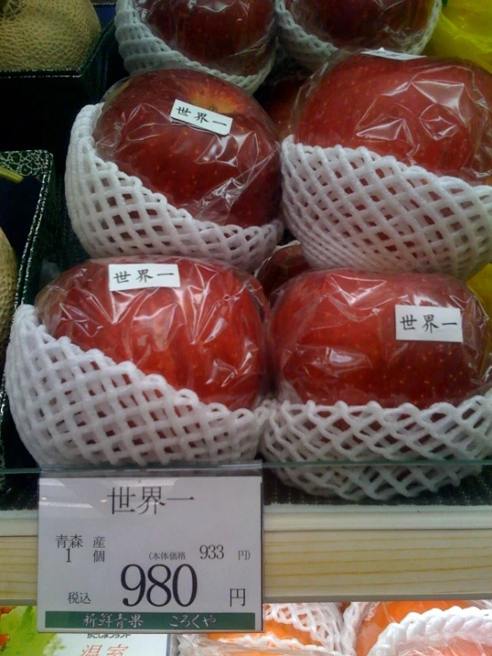 a display case at a produce market with apples on display