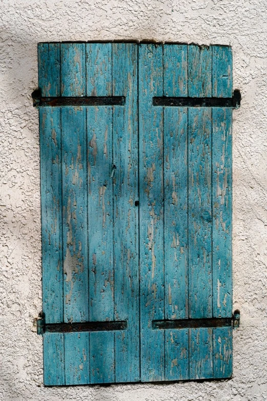 a blue closed window with old wood frame