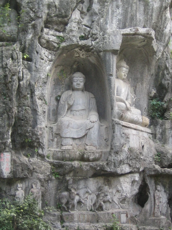 a statue sits at the bottom of a steep cliff