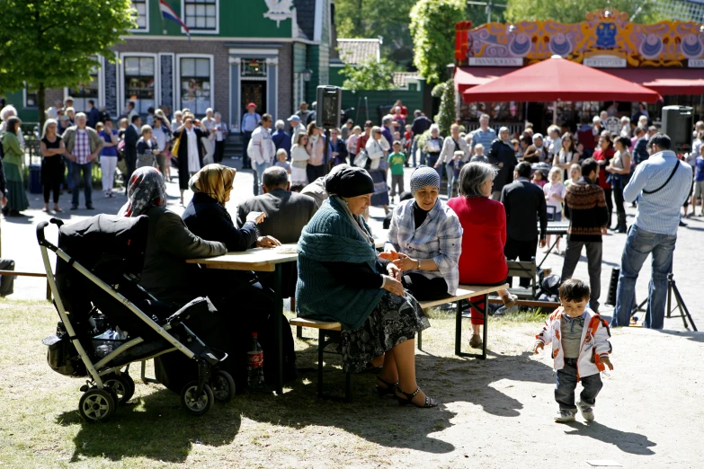 a group of people standing around a table with children