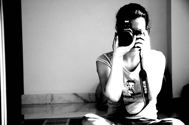 a black and white po of a woman sitting in front of a mirror