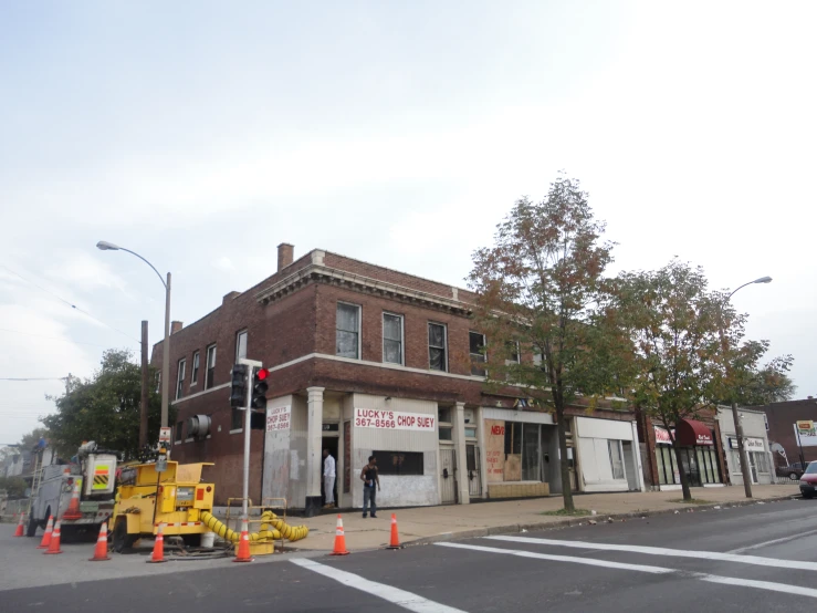 the large brick building has a yellow traffic light near it