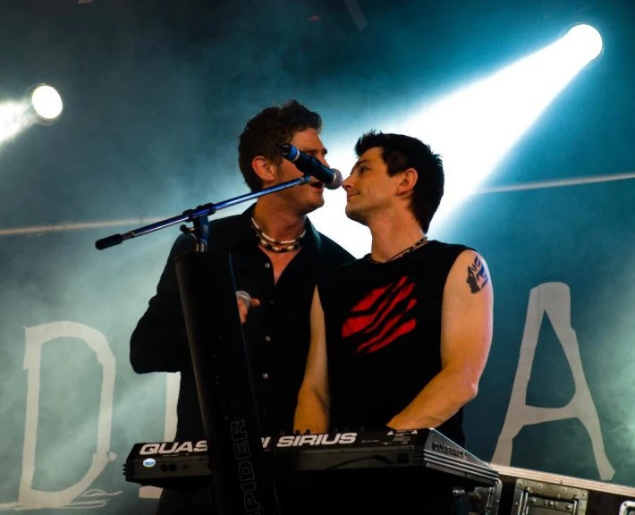 two men who are standing in front of a keyboard