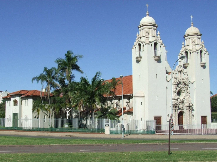 a large white church surrounded by palm trees