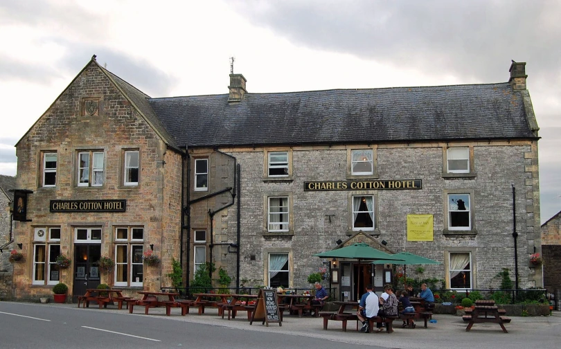 an old building with tables and benches outside