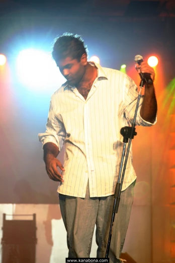 man holding microphone with striped shirt in hand