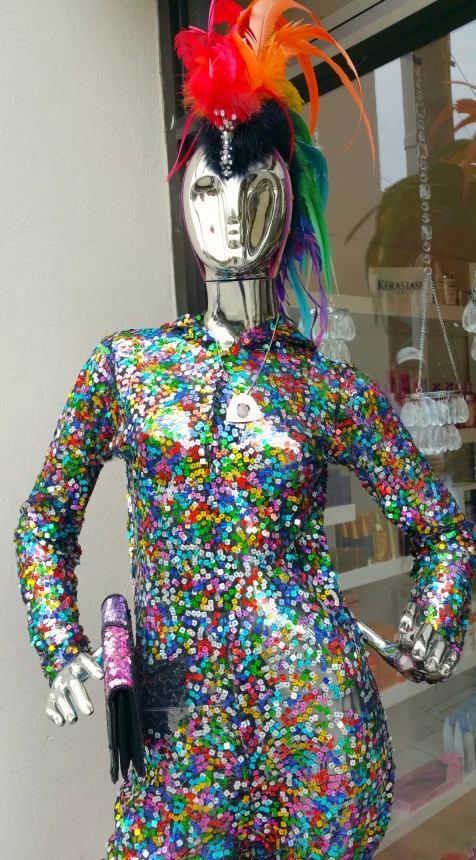 a mannequin dressed in colorful clothing stands in front of a window