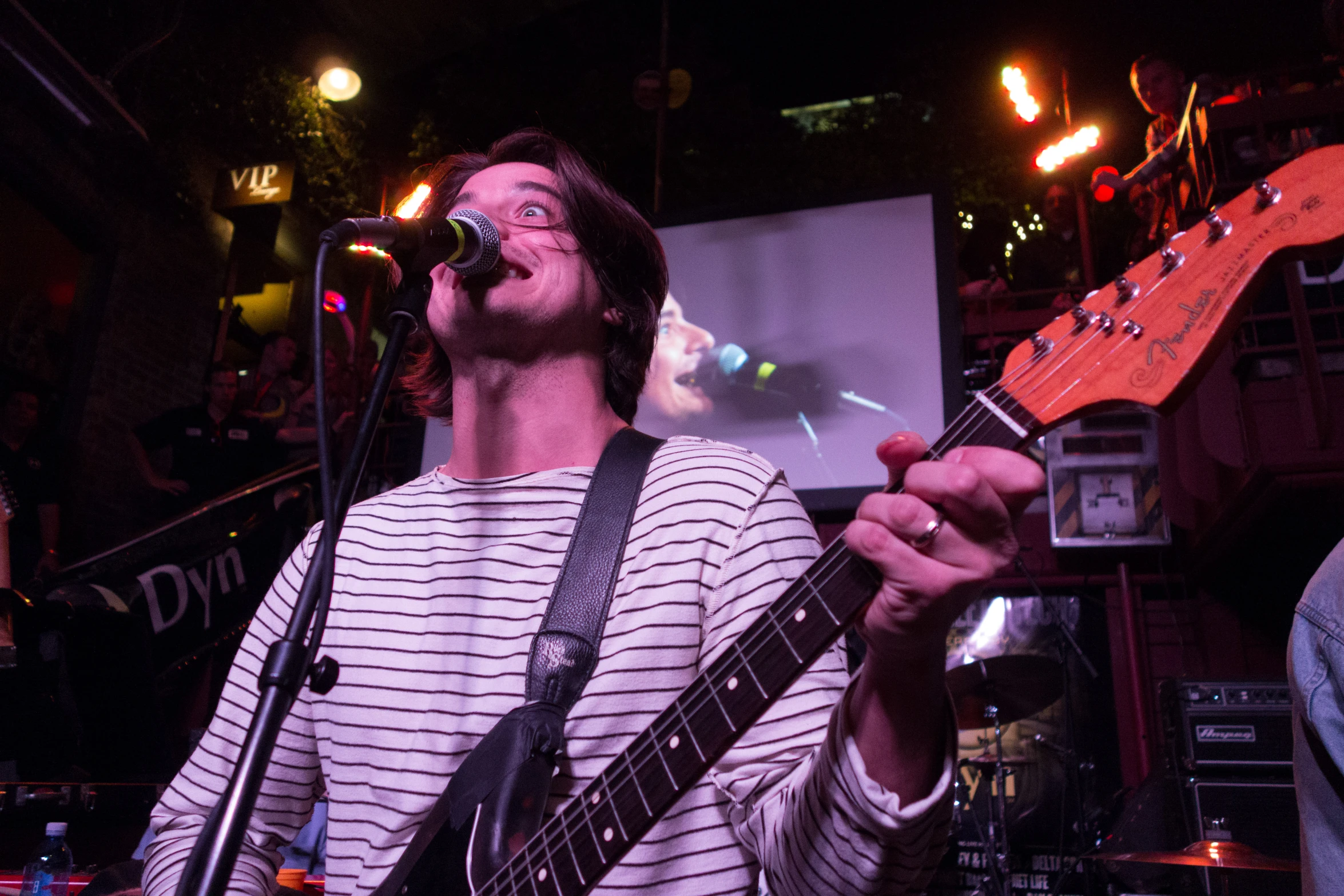 a man playing an electric guitar on a stage