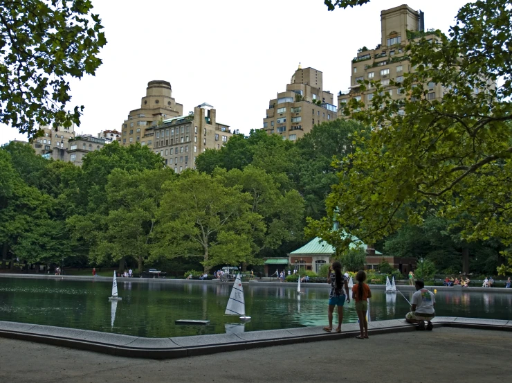 people walking along a park near the water