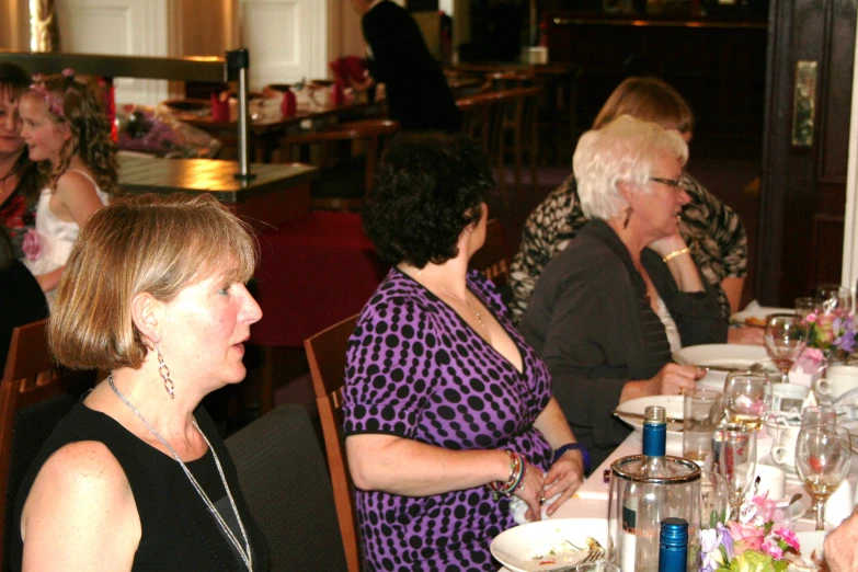 people at dinner are eating with a man looking on