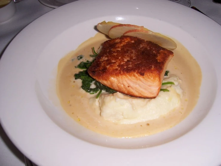 white plate topped with a food entree of mashed potatoes and green vegetables