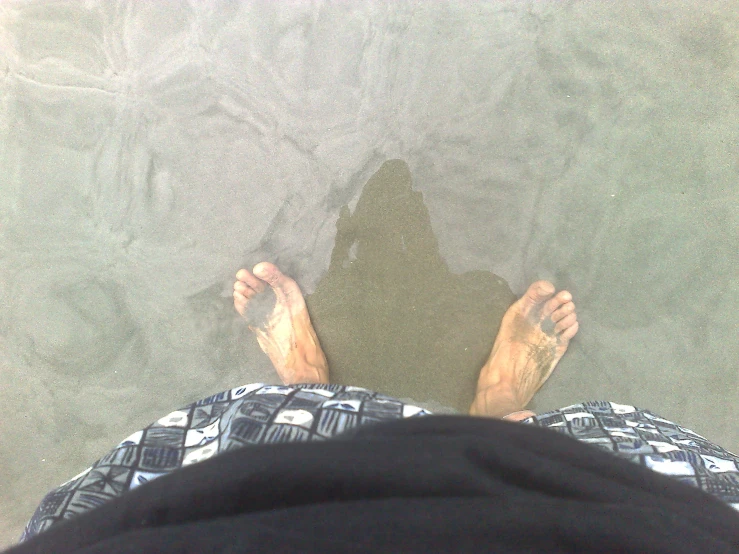 a person standing near the water's edge in shallow water