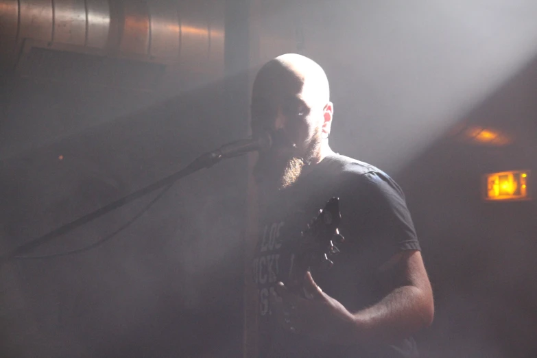 a man with a beard and black shirt is on stage with his microphone