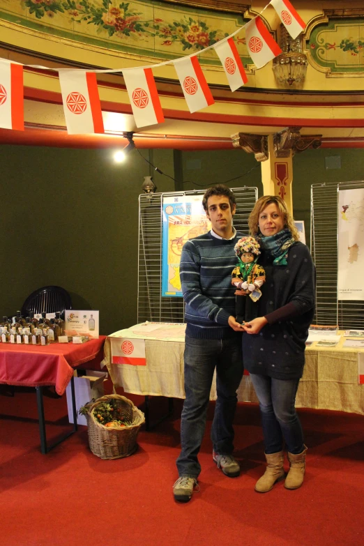 two people standing next to each other in front of tables with flags