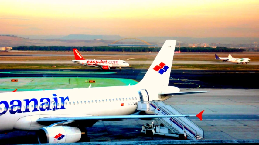 two large airplanes are on the runway of an airport