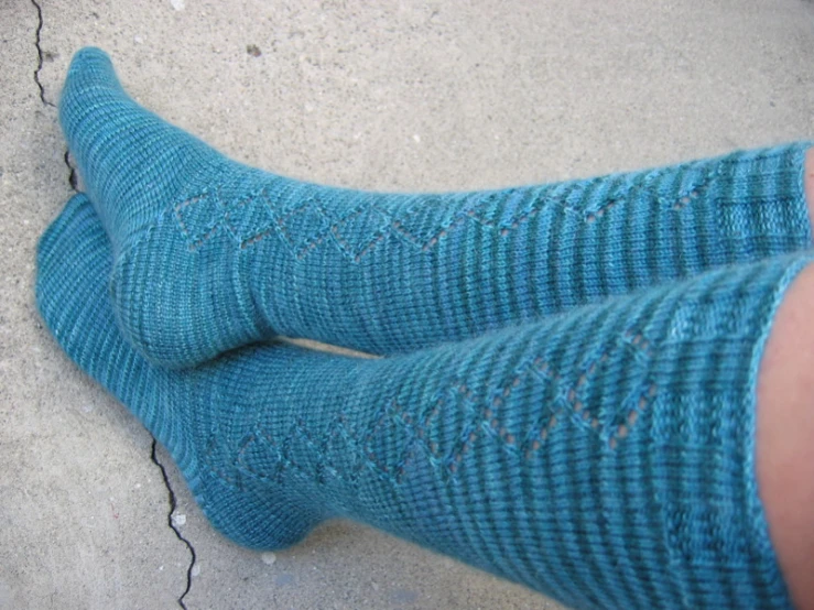 someone in green socks standing on cement