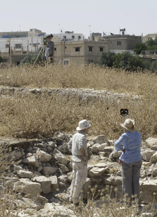 two people standing on rocks in a dry field