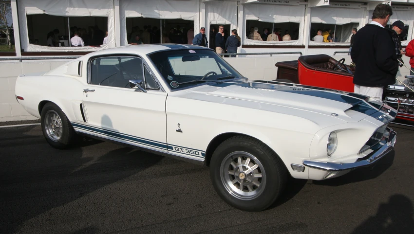 this vintage mustang car is parked on a lot