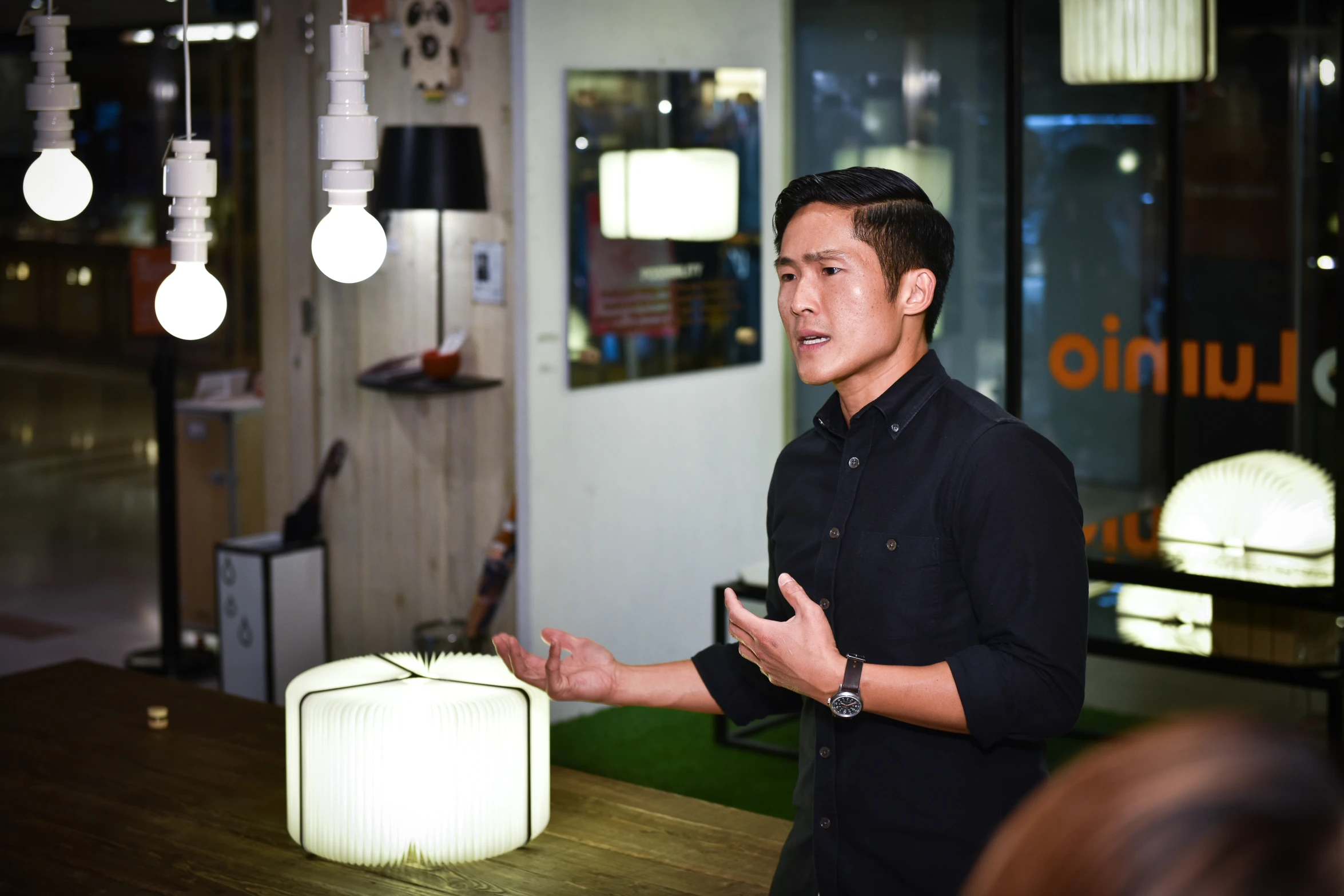 a man standing in front of a table holding a remote