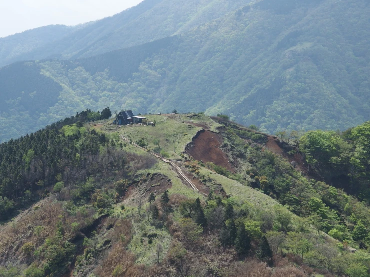 the mountains with trees on top, and some hills are in the background