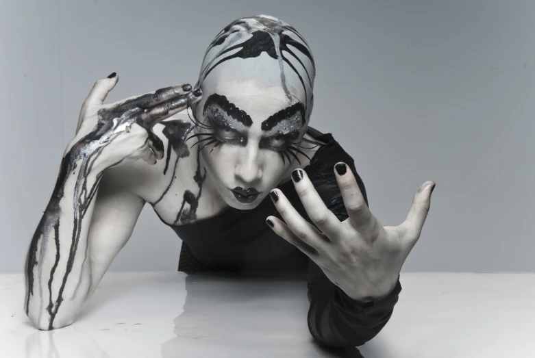 a person with black and white makeup laying on the ground