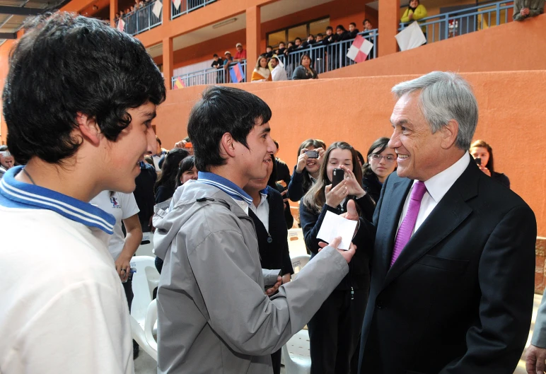 a man with a suit is talking to another man