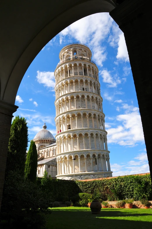 the leaning tower is seen through a small arch