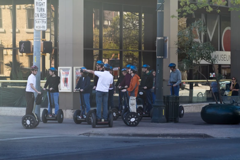 several people standing around on segways that are standing in the street