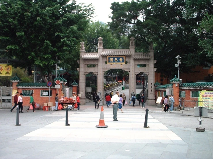 some people walking down the sidewalk outside of a shrine