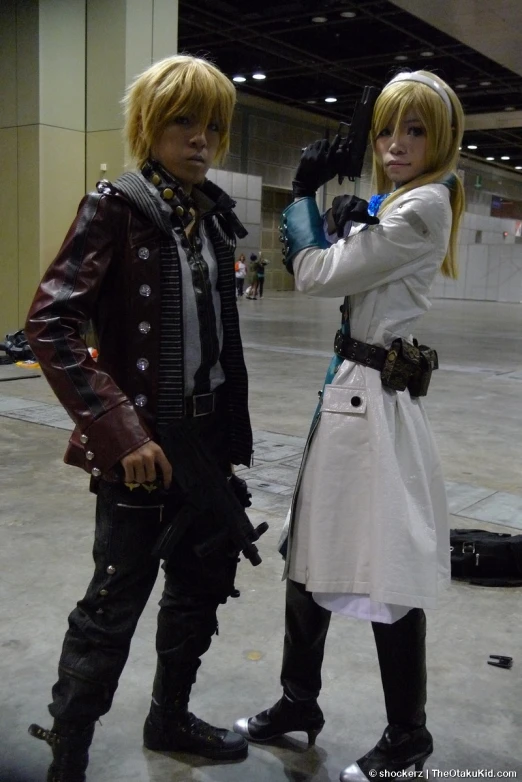 two people dressed in anime costumes holding a gun