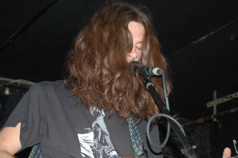 a long haired man plays an electric guitar