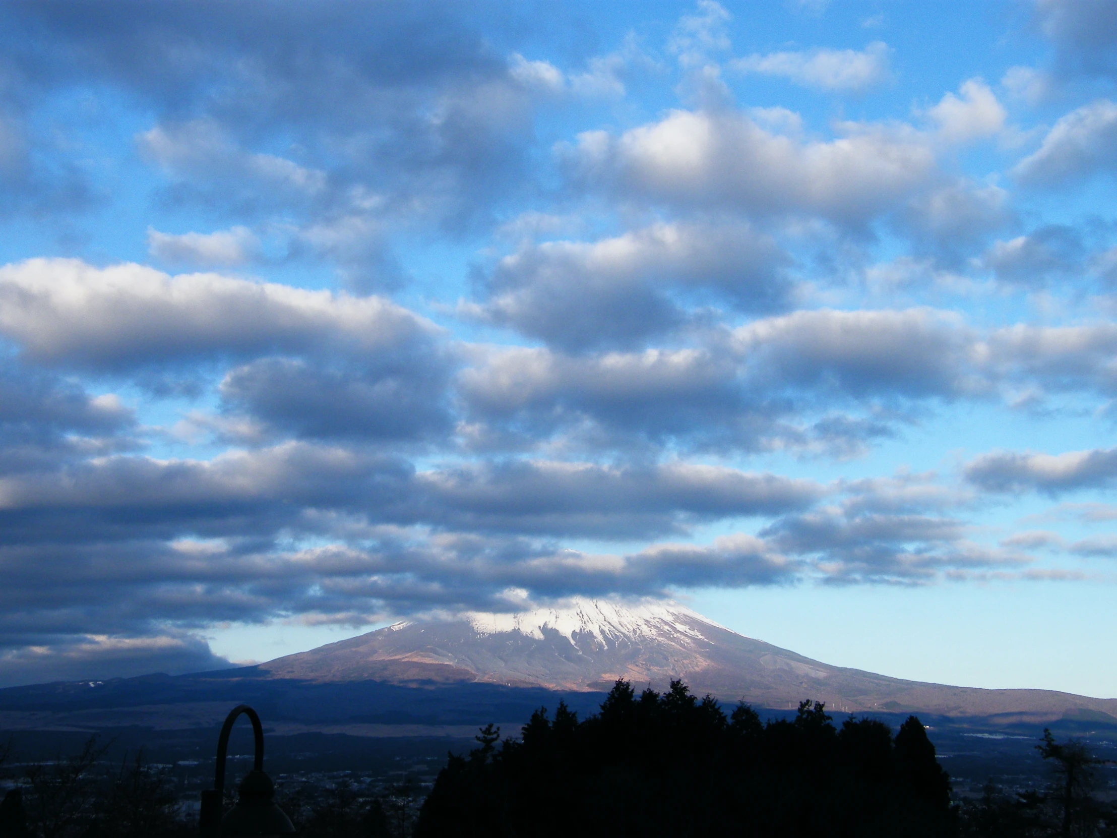 clouds are above the top of a mountain