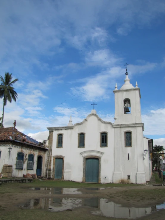 a white church sits alone on the side of a road