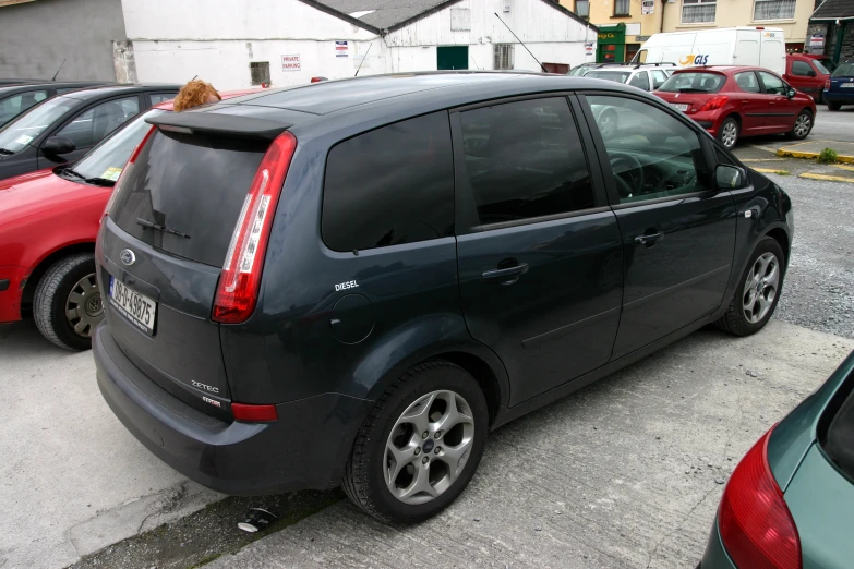 the grey car is parked by itself near other cars