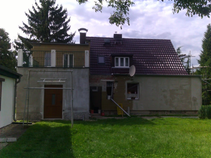 two building with a green grass yard and trees