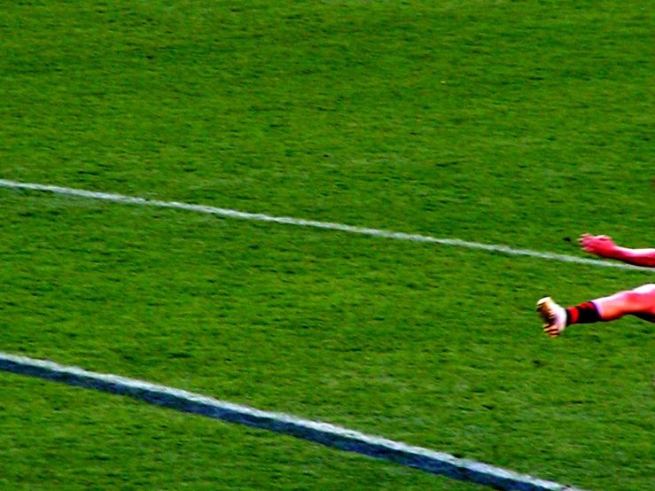 a soccer player is reaching to catch the ball