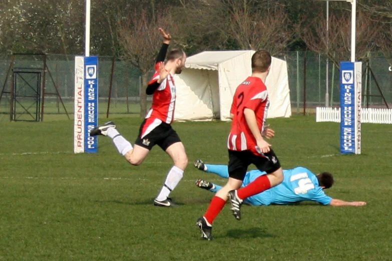 two young men running after a soccer ball on a field