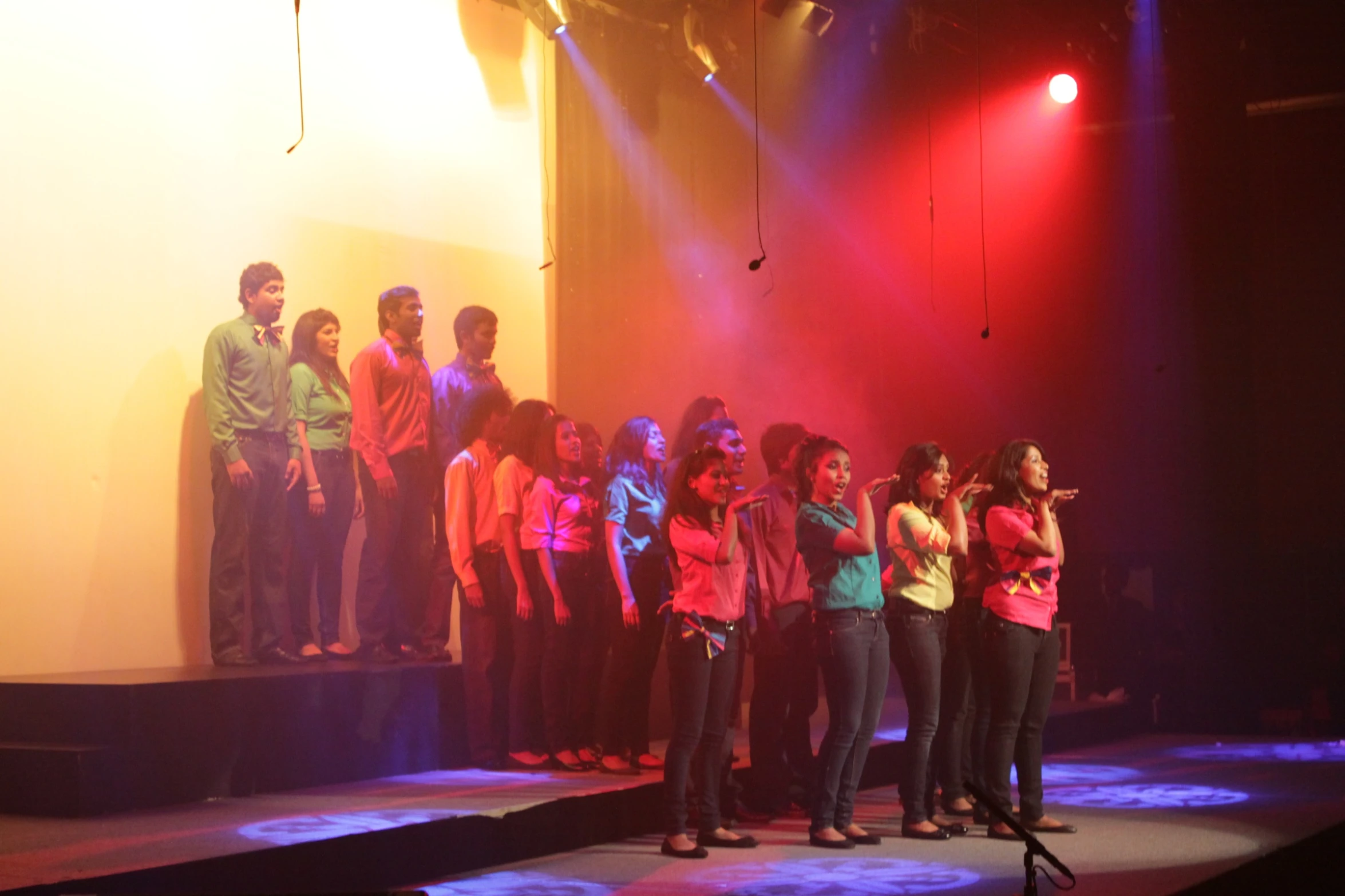 several people stand on a stage and sing