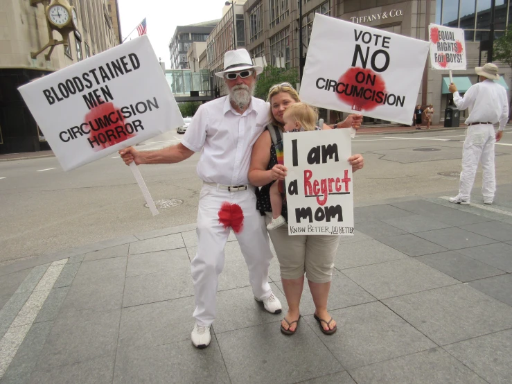 a man and woman holding signs on the sidewalk